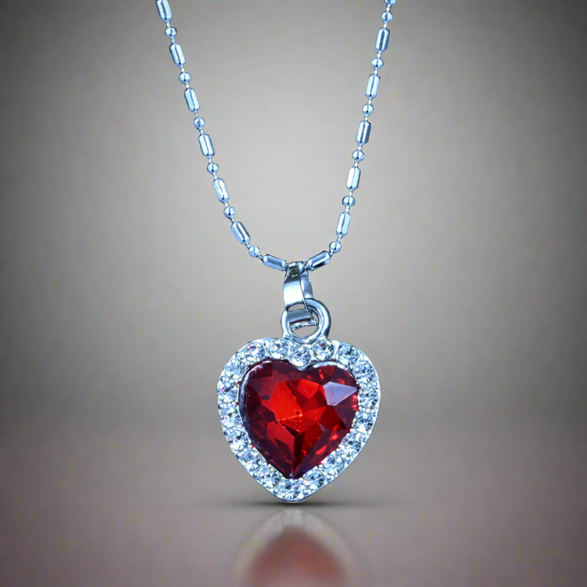 Pendant Shaped Like Heart with Red Stone & Small Silver Gems Around it, Plus a Silver Chain